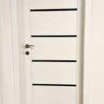 Detail bielych interiérových drevených dverí Prešov s minimalistickým dizajnom.