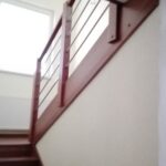 Drevené schody Žilina s masívnym zábradlím a nerezovými výplňami.